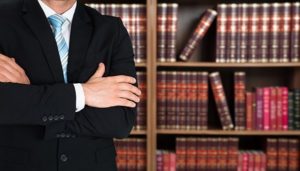 Lawyer standing against books in shelves 600x341